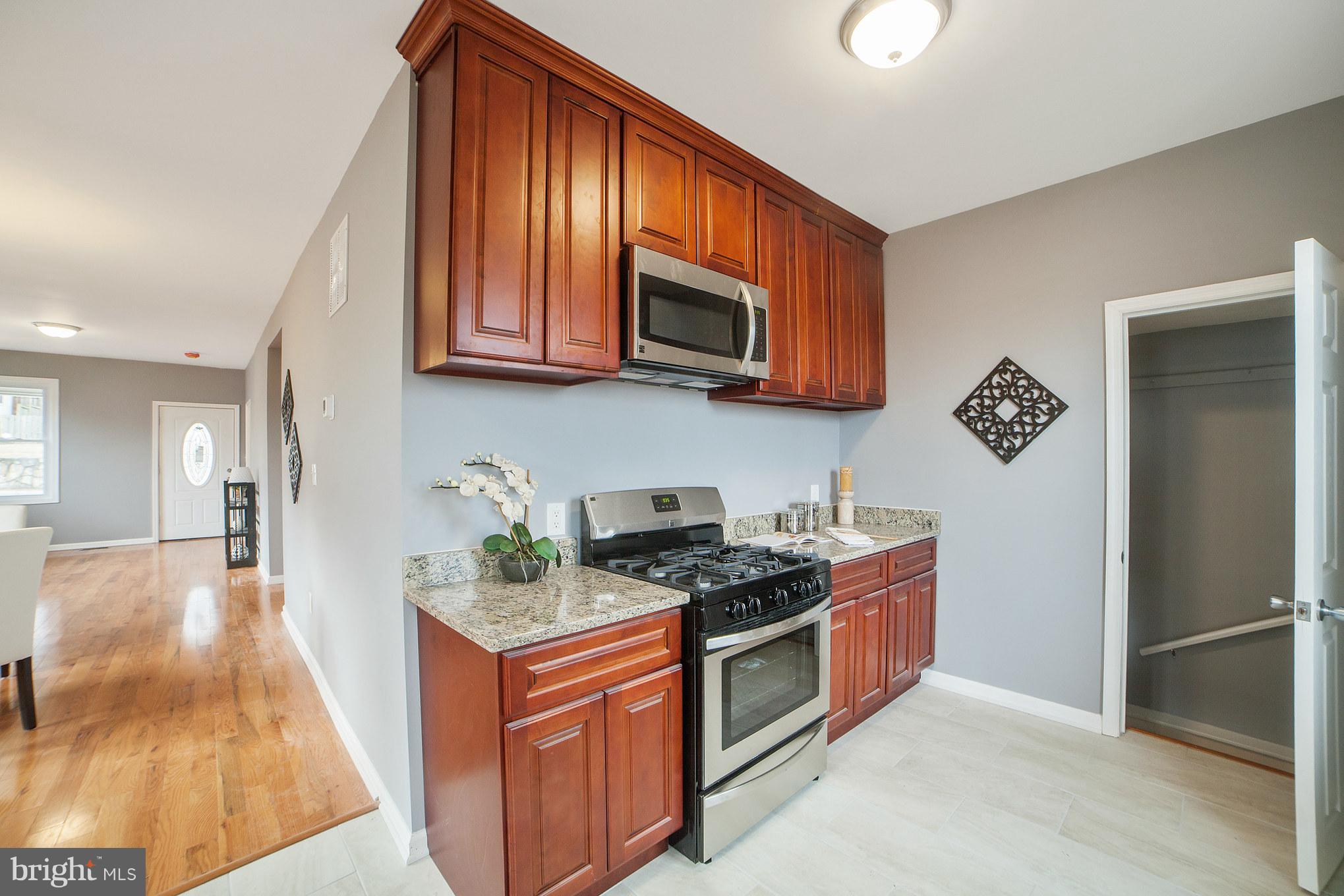 114 West Edgevale Road Baltimore, MD 21225 - Photo 8 of 22 a kitchen with stainless steel appliances granite countertop a stove a sink and a microwave