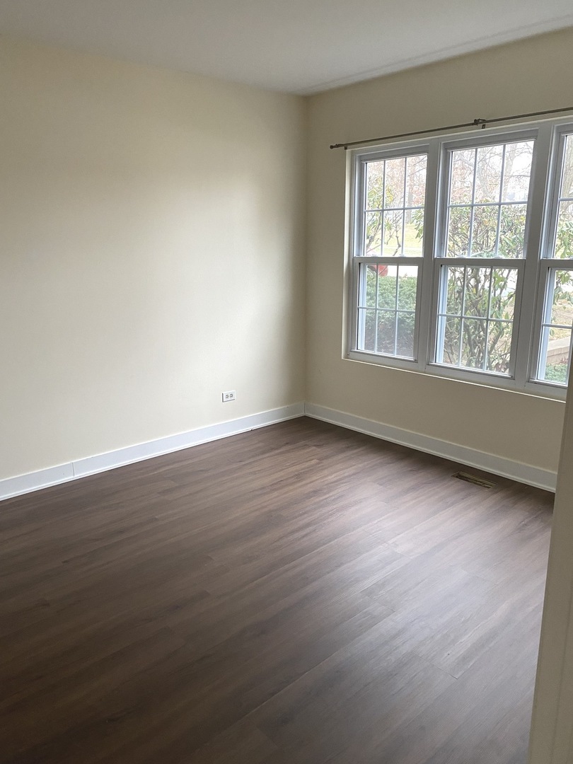 247 Ascot Lane Streamwood, IL 60107 - Photo 12 of 21 an empty room with wooden floor and windows
