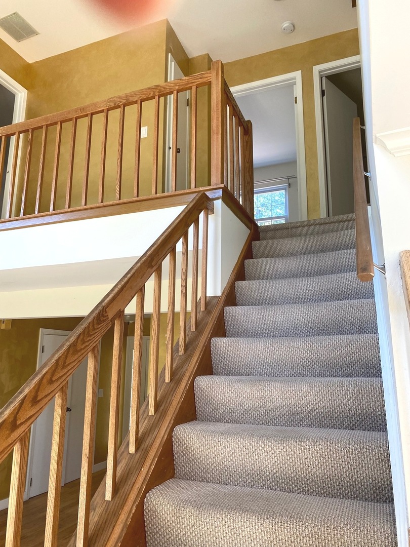 247 Ascot Lane Streamwood, IL 60107 - Photo 14 of 21 a view of staircase with lots of frames on wall