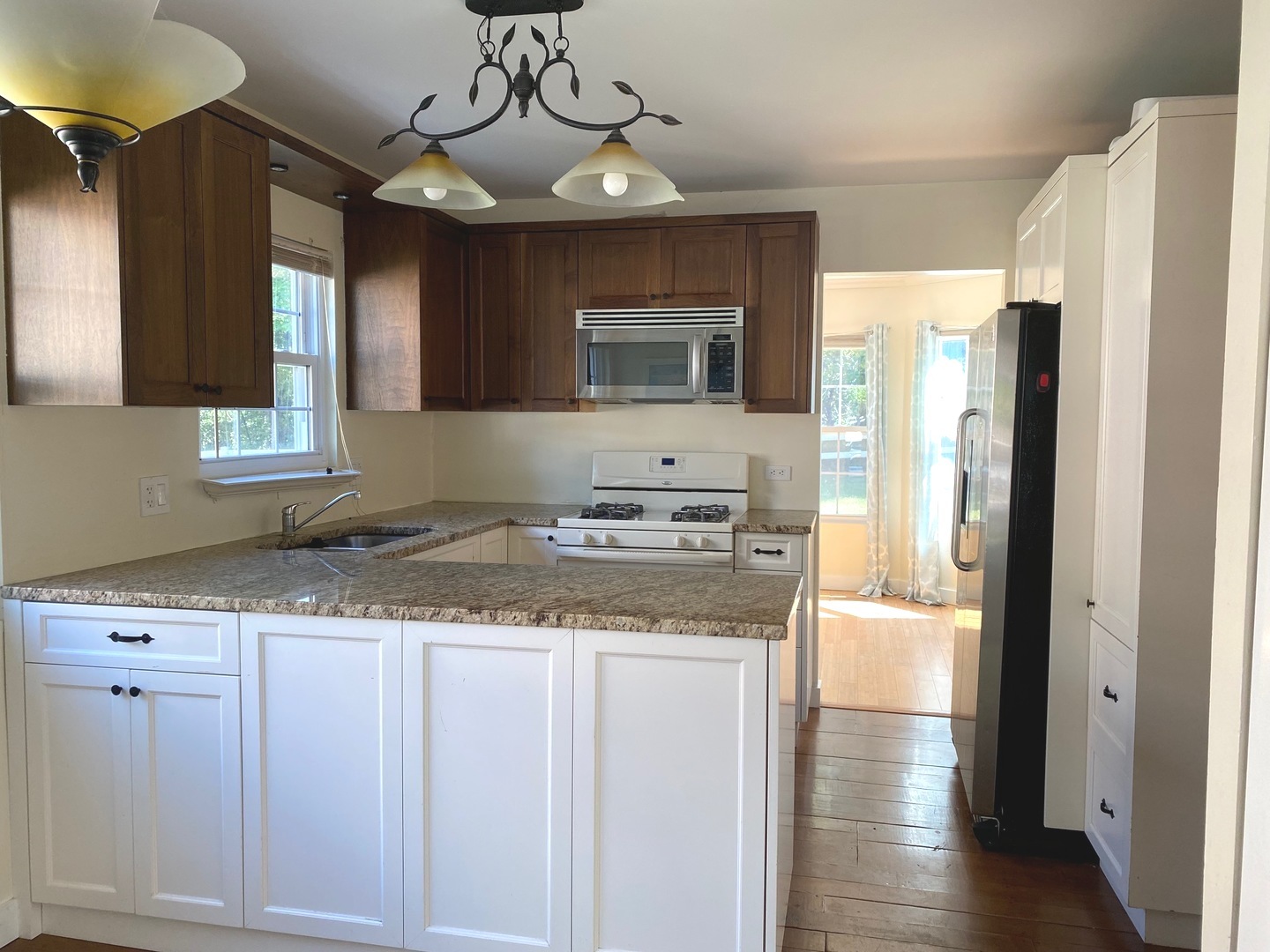 247 Ascot Lane Streamwood, IL 60107 - Photo 4 of 21 a kitchen with stainless steel appliances granite countertop a refrigerator a oven and white cabinets with wooden floor