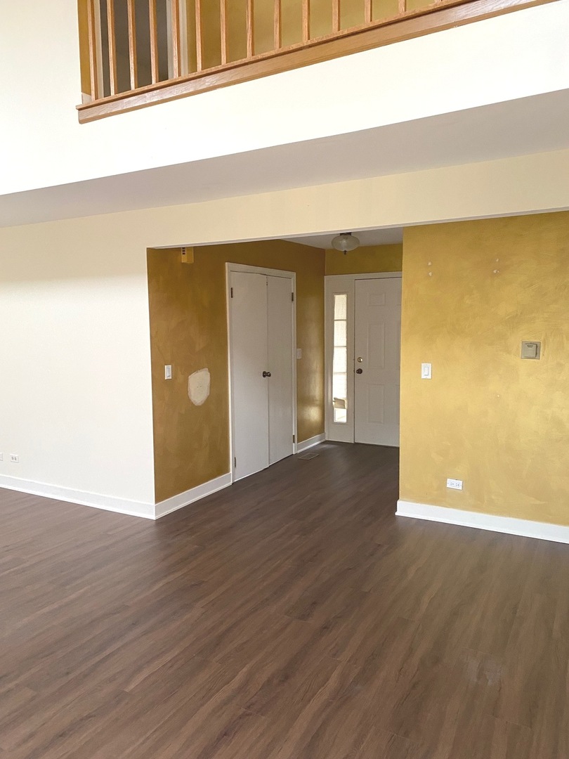 247 Ascot Lane Streamwood, IL 60107 - Photo 8 of 21 a view of an empty room with wooden floor and a window