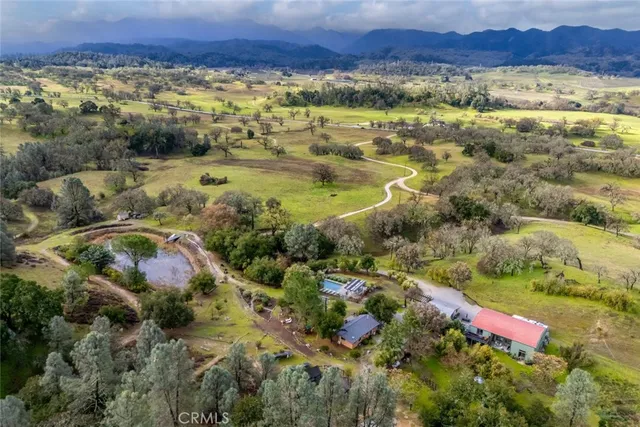 a living room with furniture and a dining table with kitchen appliances