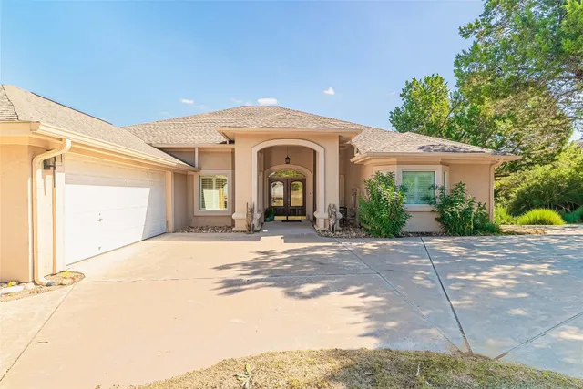 a view of a house with a yard and potted plants