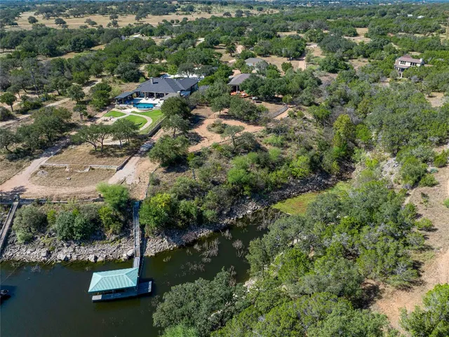 an aerial view of a house with a yard and lake view