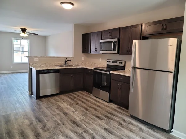 a kitchen with stainless steel appliances granite countertop a refrigerator a sink a stove a microwave and island