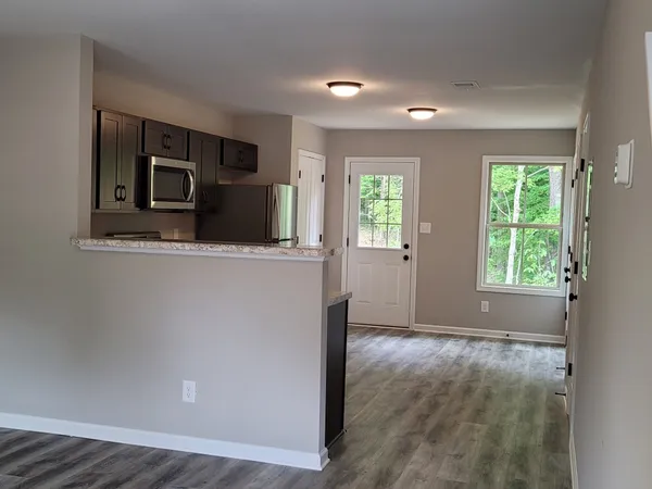 a view of a kitchen with an entryway and wooden floor