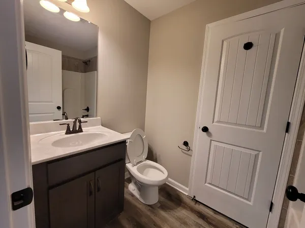a bathroom with a toilet a sink and a mirror
