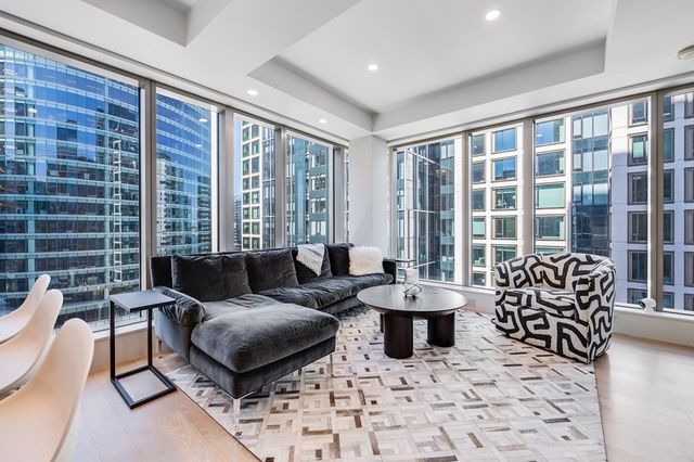 a living room with furniture and large windows