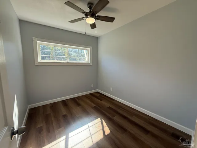a view of room with wooden floor and fan