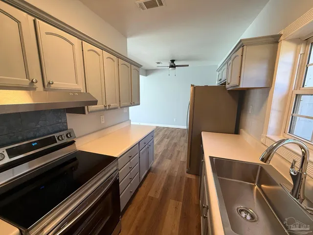 a kitchen with granite countertop a stove and a refrigerator