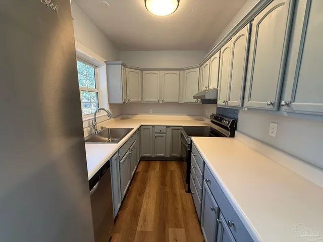 a kitchen with a sink a counter top space and cabinets