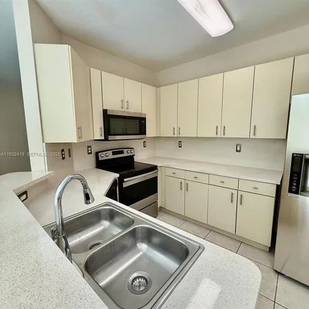 a kitchen with a sink cabinets and a stove