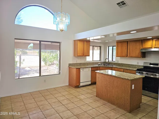 a kitchen with granite countertop a sink a stove and cabinets