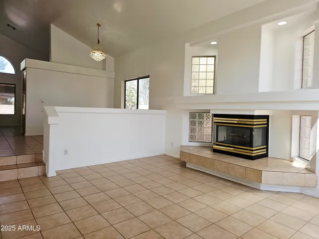 an empty room with windows and fireplace