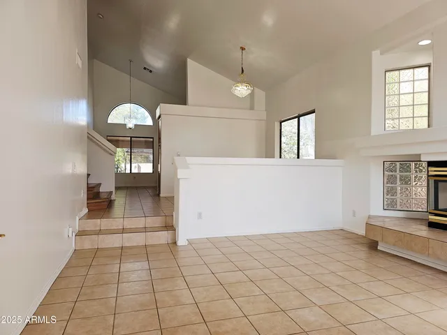 an empty room with kitchen and windows