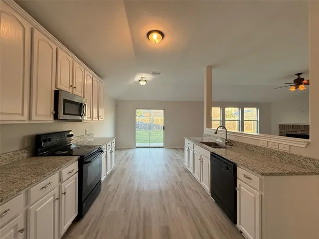 a kitchen with stainless steel appliances granite countertop a sink stove microwave and cabinets