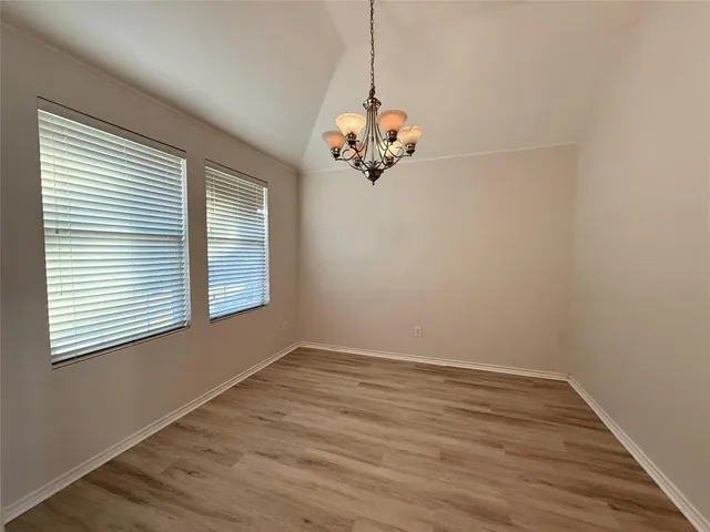 a view of a room with wooden floor fan and windows