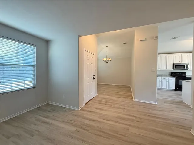 a view of a kitchen with wooden floor and a refrigerator