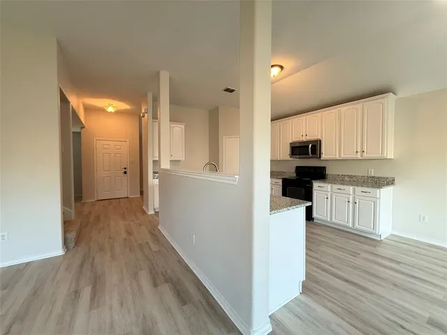 a kitchen with white cabinets and stainless steel appliances