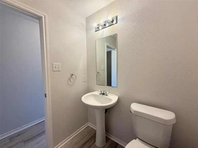 a bathroom with a toilet a sink and mirror