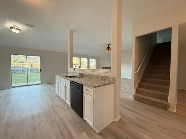 a kitchen with granite countertop a stove and a wooden floors