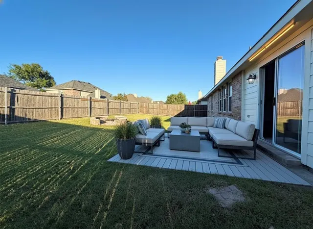 a view of a patio with couches table and chairs with plants and garden