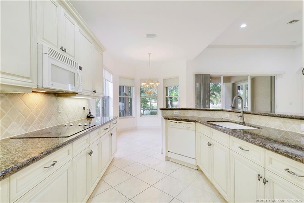 736 Southwest Pebble Lane Palm City, FL 34990 - Photo 15 of 54 a large kitchen with granite countertop a sink and cabinets