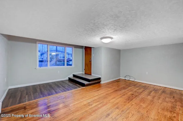 a view of a room with wooden floor and window