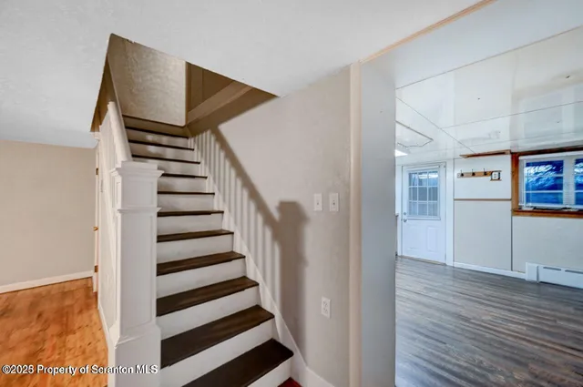 a view of a hallway with wooden floor and entryway