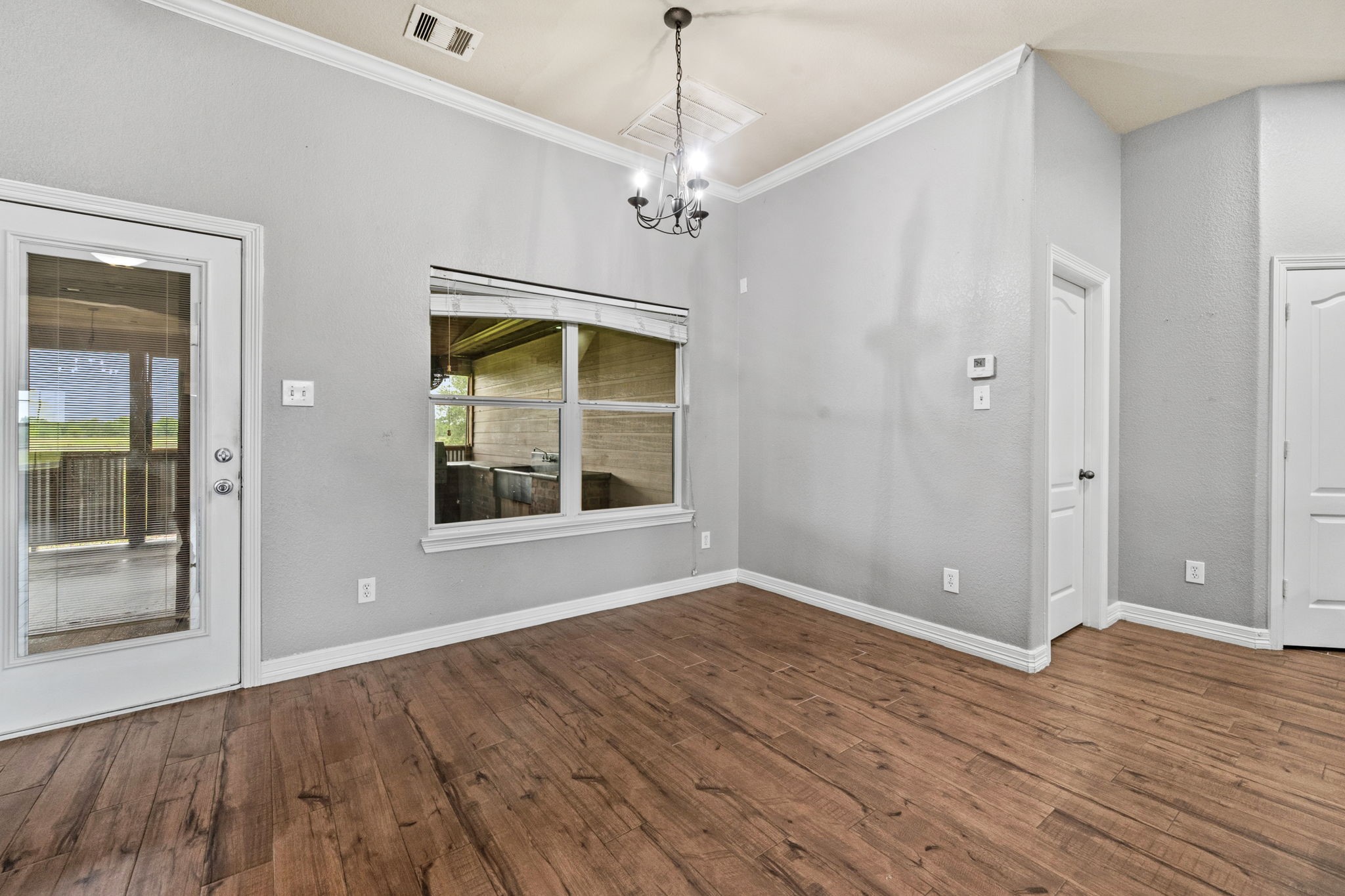 1405 Big Hill Road Winnie, TX 77665 - Photo 23 of 43 a view of an empty room with wooden floor and a window