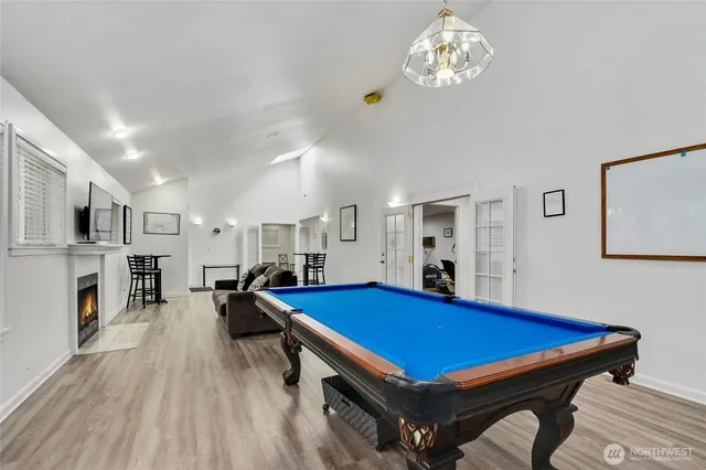 a room with furniture pool table flat screen tv and a chandelier