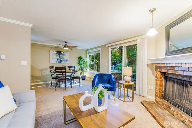 a living room with furniture a fireplace and a floor to ceiling window