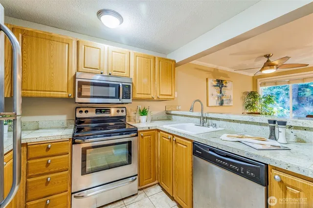 a kitchen with stainless steel appliances granite countertop a sink stove and microwave