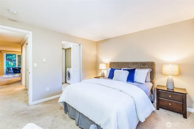 a spacious bedroom with a bed and a lamp