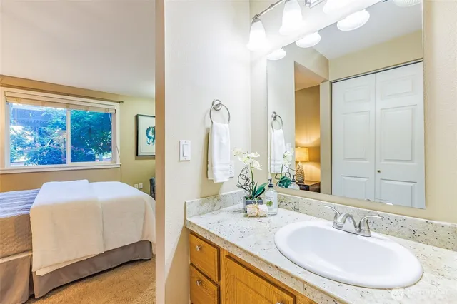 a en suite bathroom with a granite countertop sink and a mirror