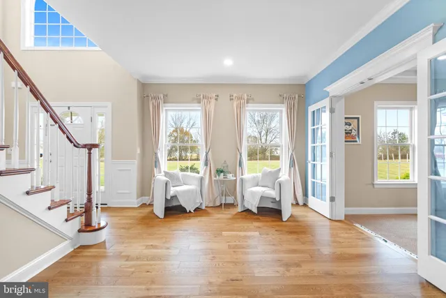 a dining room with wooden floor a chandelier a glass table and chairs