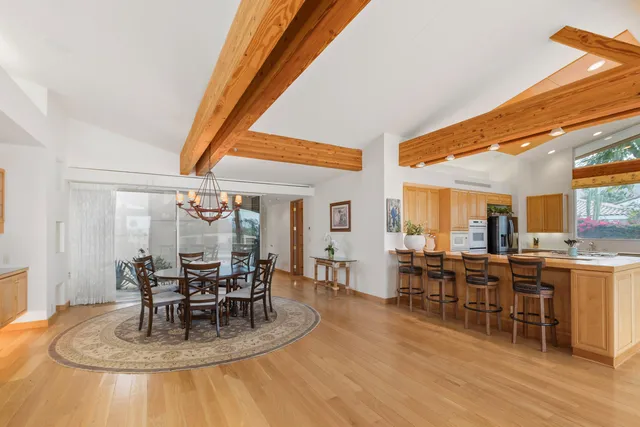 a dining room with furniture a chandelier and wooden floor