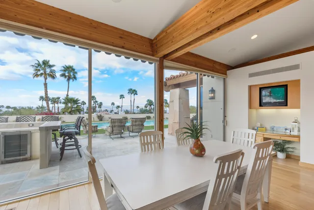 a dining room with furniture a large window and a chandelier