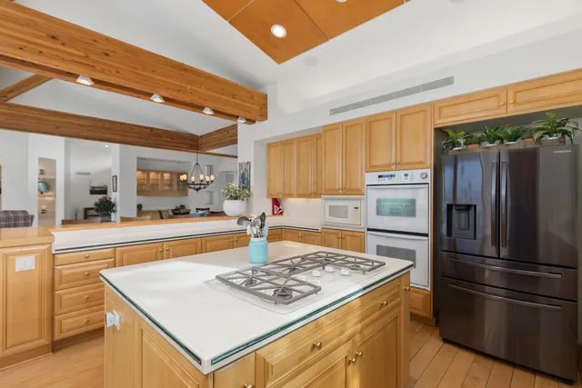 a kitchen with stainless steel appliances granite countertop a sink a stove and refrigerator