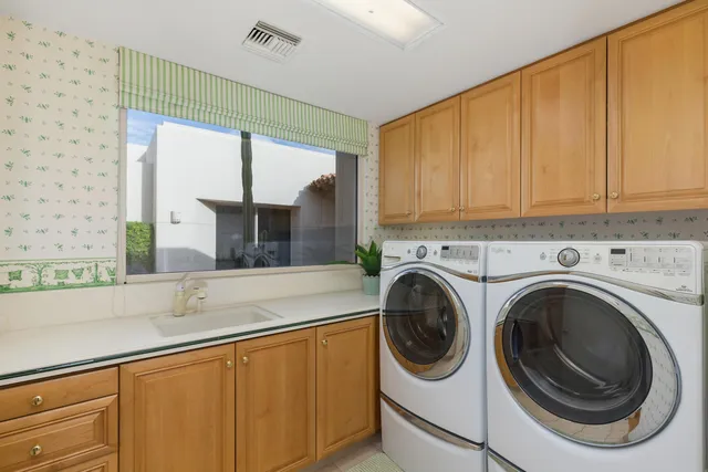 a kitchen with a sink a washer and dryer next to a window