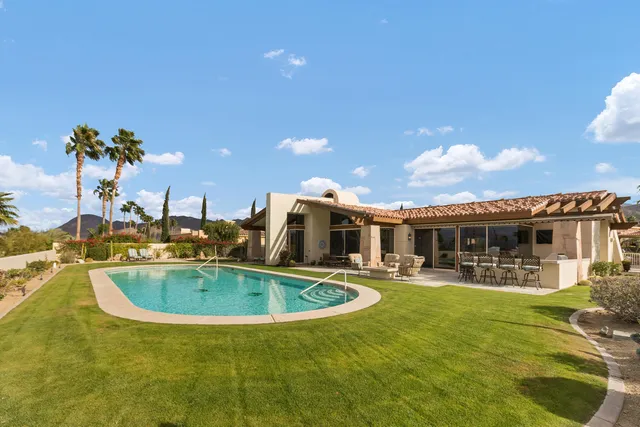 a view of a house with swimming pool and a yard