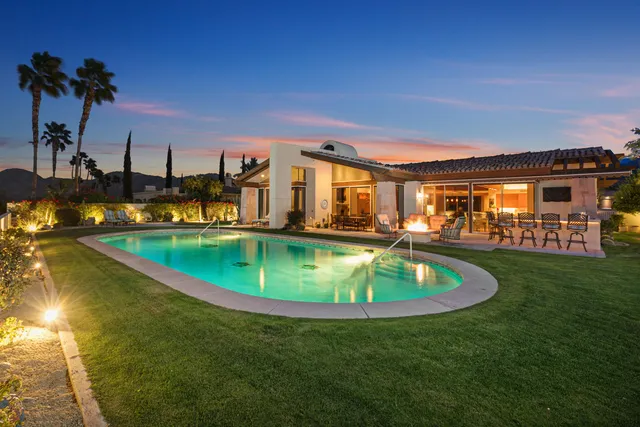 a view of a house with swimming pool and sitting area
