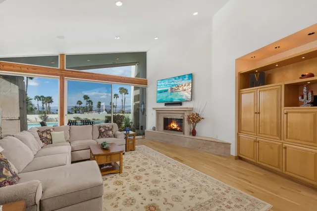 a living room with fireplace furniture and a floor to ceiling window