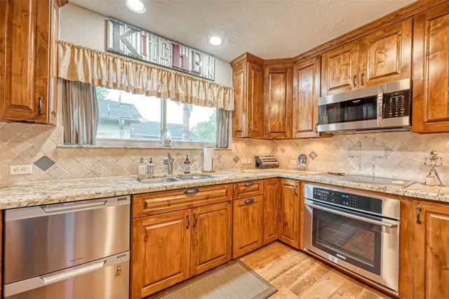 a kitchen with granite countertop stainless steel appliances white cabinets granite counter tops and a window