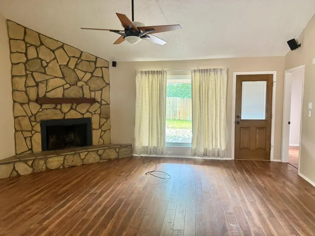 a view of a livingroom with wooden floor and a fireplace