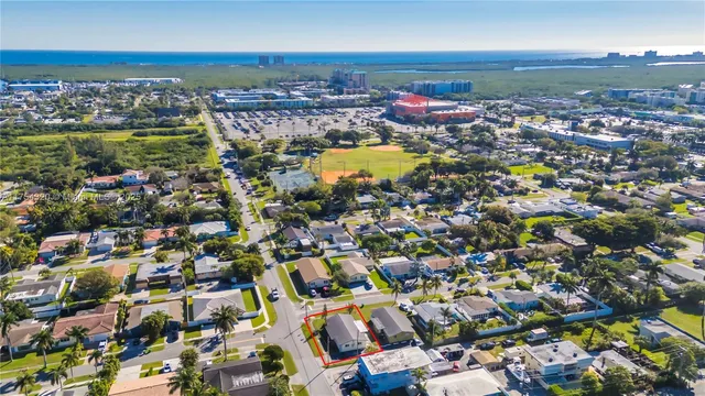 an aerial view of a city with lots of residential buildings and ocean view in back