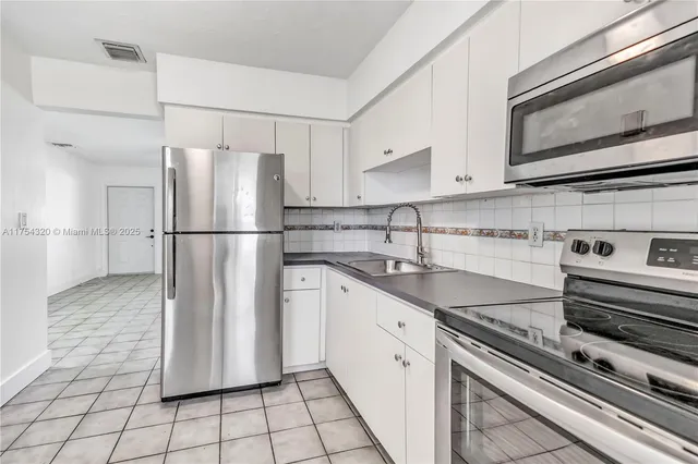 a kitchen with appliances cabinets and a sink