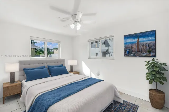 a bedroom with a large bed and a potted plant