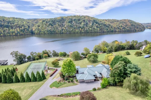 an aerial view of residential houses with outdoor space and lake view