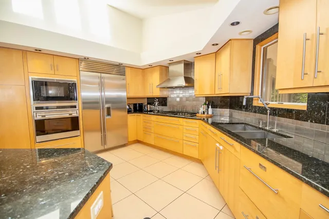 a living room with furniture a flat screen tv and floor to ceiling window